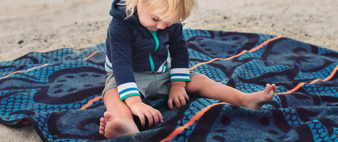 The basotho blanket on a beach with a small toddle on it 